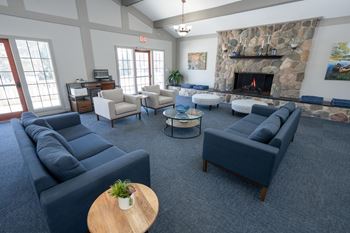 A living room with a stone fireplace and a variety of seating options